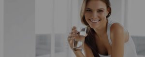 lady drinking a glass of water in the kitchen